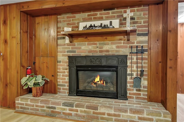 room details with hardwood / wood-style flooring, a fireplace, and wood walls