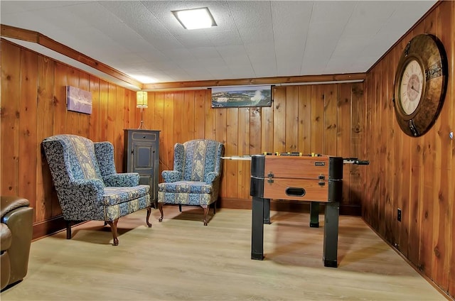 game room with wood walls and light wood-type flooring