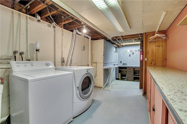 washroom featuring separate washer and dryer, a workshop area, and cabinets