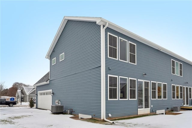 back of house featuring a garage and central air condition unit