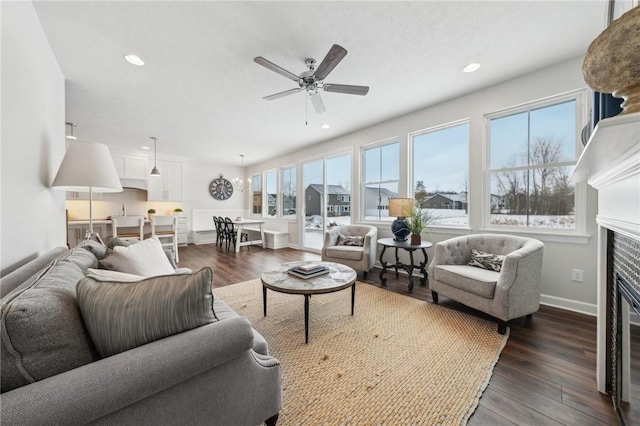 living room featuring dark wood-type flooring and ceiling fan