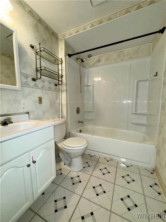 full bathroom with vanity, toilet, tile walls, and bathing tub / shower combination