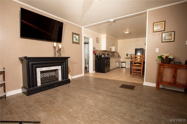 living room featuring crown molding, a fireplace, and wood-type flooring