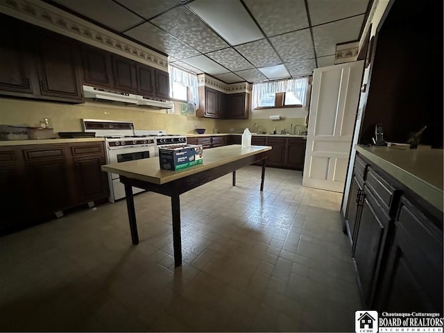 kitchen with white range with gas cooktop, dark brown cabinetry, and a drop ceiling