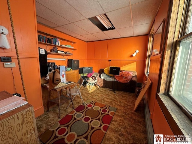 interior space featuring dark colored carpet and a drop ceiling