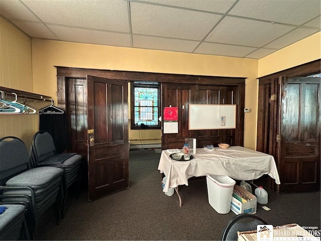 carpeted dining space featuring a drop ceiling and baseboard heating