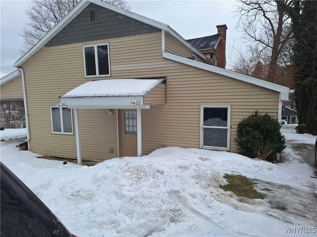 view of snow covered rear of property