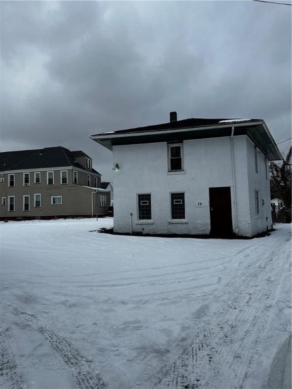 view of snow covered back of property