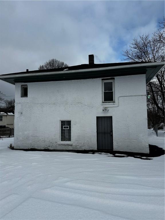 view of snow covered rear of property