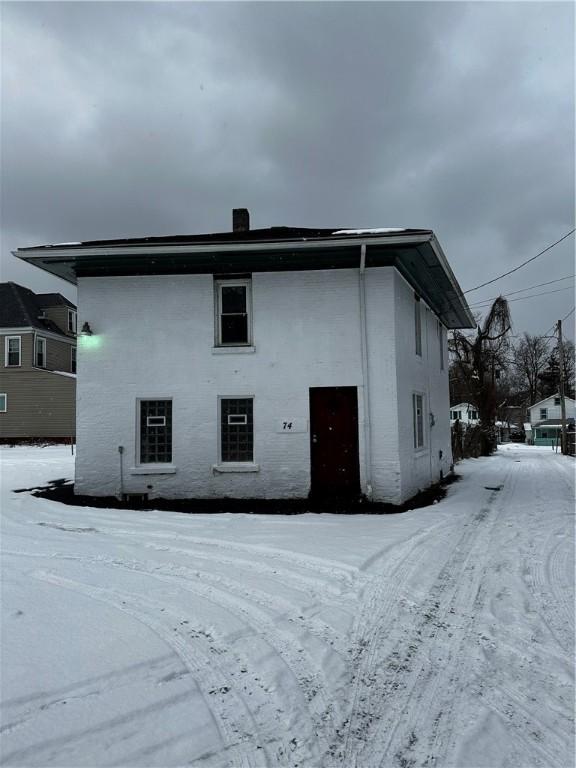 view of snow covered rear of property