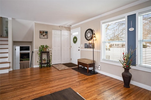 foyer entrance with hardwood / wood-style floors and crown molding