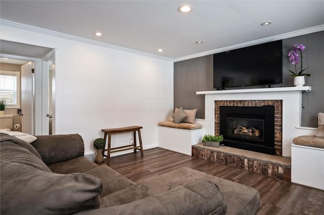 living room featuring ornamental molding, dark hardwood / wood-style floors, and a brick fireplace