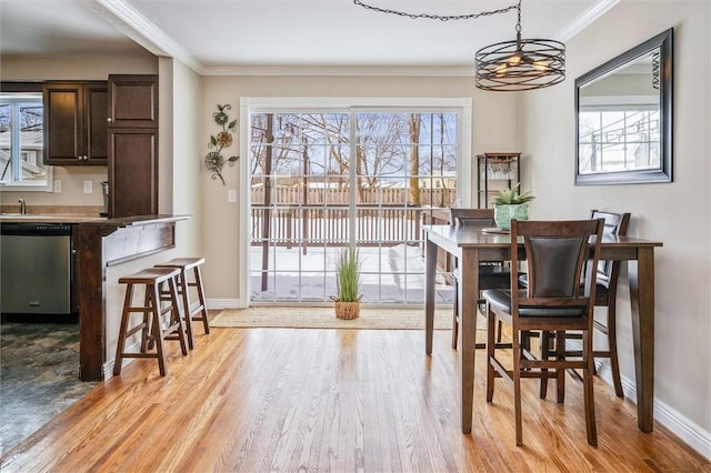 dining room with ornamental molding and light wood-type flooring