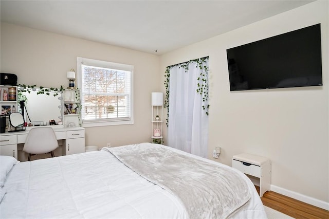 bedroom with hardwood / wood-style flooring and built in desk