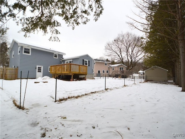 snow covered back of property featuring a wooden deck