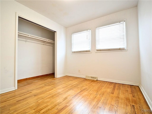 unfurnished bedroom with a closet and light wood-type flooring