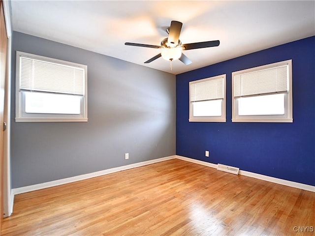 unfurnished room with ceiling fan, light hardwood / wood-style floors, and a wealth of natural light