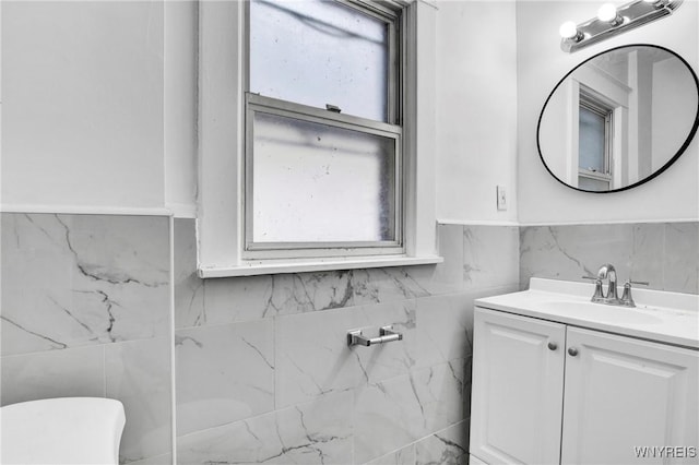 bathroom with vanity and tile walls