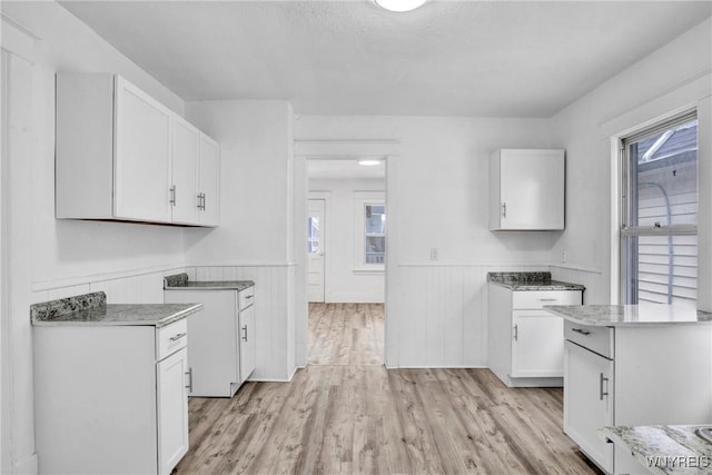 kitchen with white cabinetry and light hardwood / wood-style floors