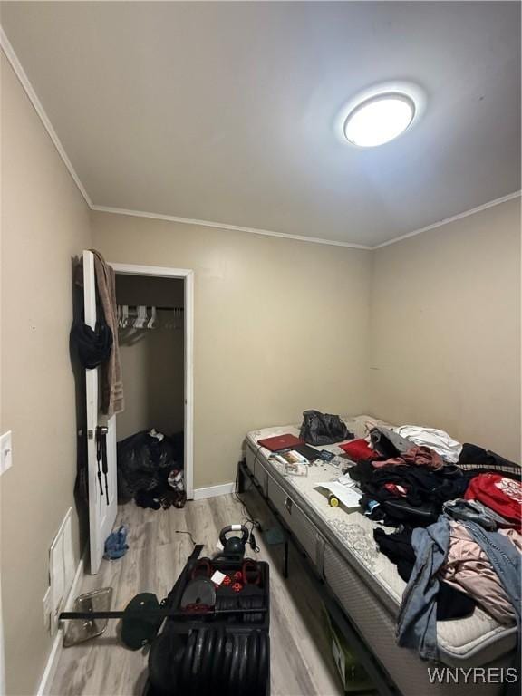 bedroom with crown molding and light wood-type flooring