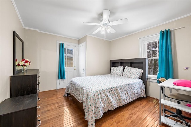 bedroom with crown molding, wood-type flooring, and ceiling fan