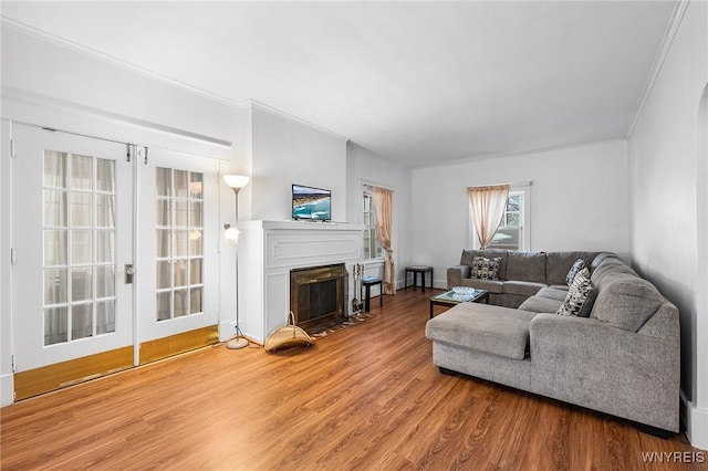 living room featuring hardwood / wood-style flooring, ornamental molding, and french doors