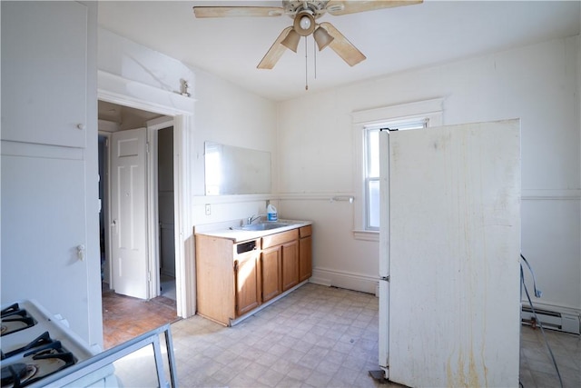 kitchen with ceiling fan, a baseboard radiator, white refrigerator, and sink