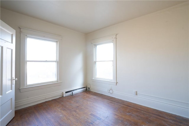 spare room featuring dark hardwood / wood-style flooring and a baseboard heating unit