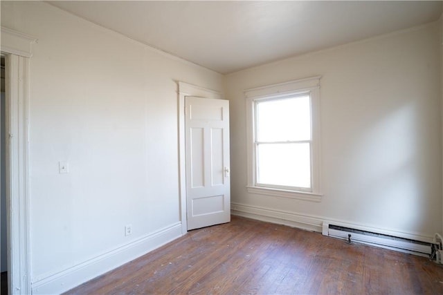 empty room with a baseboard radiator and dark hardwood / wood-style floors