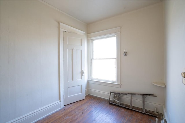 unfurnished room featuring dark hardwood / wood-style flooring and crown molding