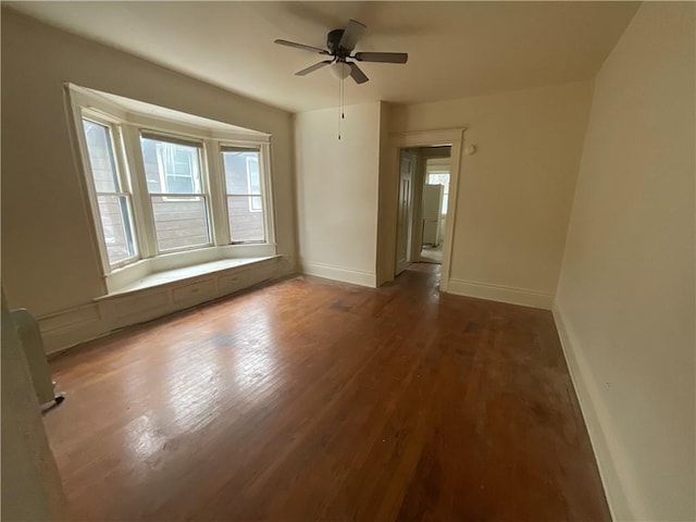 spare room with ceiling fan and dark hardwood / wood-style flooring