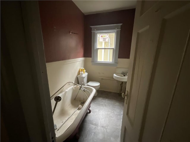 bathroom featuring a tub to relax in and toilet