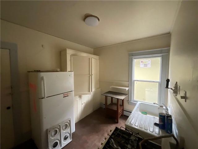 kitchen with white cabinetry, a baseboard radiator, and white fridge