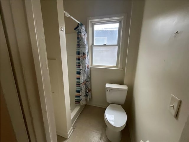 bathroom with a shower with shower curtain and toilet