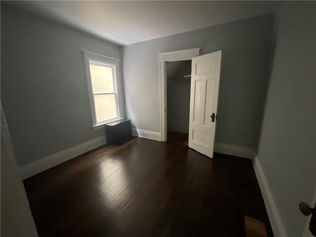 unfurnished bedroom featuring a closet and dark hardwood / wood-style floors