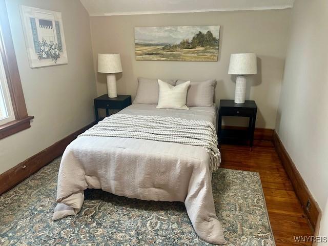 bedroom featuring dark hardwood / wood-style flooring and vaulted ceiling