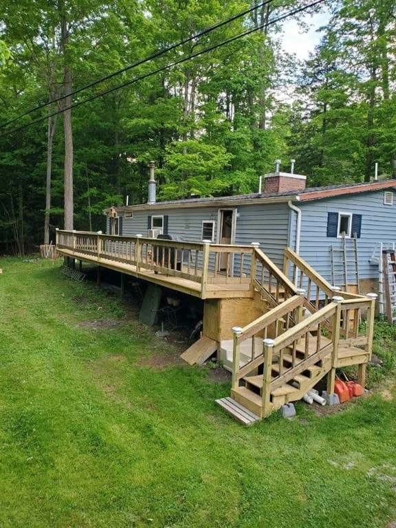 back of house featuring a wooden deck and a lawn