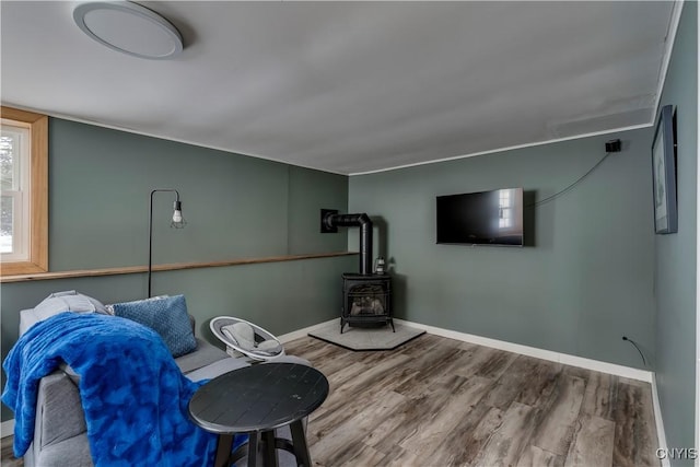 unfurnished room featuring wood-type flooring and a wood stove