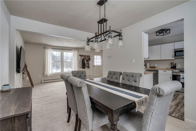 carpeted dining room with a baseboard radiator and a textured ceiling