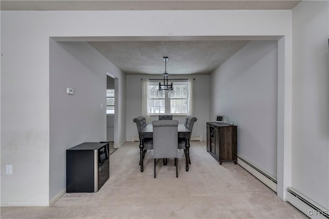 dining room featuring an inviting chandelier, light carpet, and a baseboard heating unit