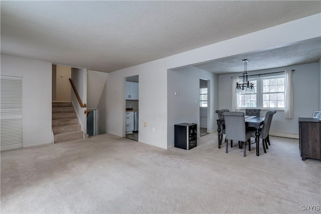 dining room with an inviting chandelier, a baseboard heating unit, light colored carpet, and a textured ceiling