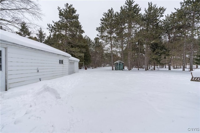 yard covered in snow featuring a garage