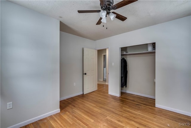 unfurnished bedroom featuring ceiling fan, light hardwood / wood-style floors, a closet, and a textured ceiling