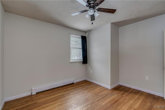 empty room with ceiling fan, a baseboard radiator, a textured ceiling, and light wood-type flooring