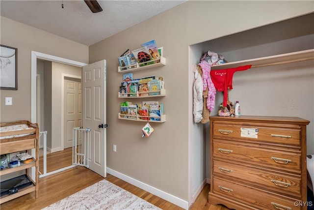 interior space featuring ceiling fan, light hardwood / wood-style flooring, and a textured ceiling