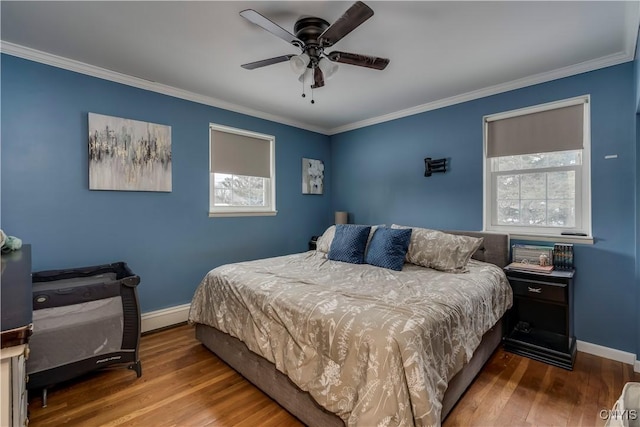 bedroom with hardwood / wood-style floors, crown molding, and ceiling fan