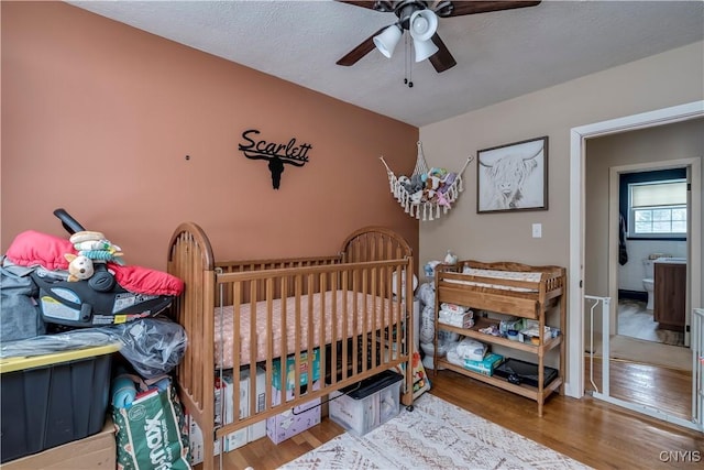 bedroom featuring ceiling fan, wood-type flooring, and a textured ceiling