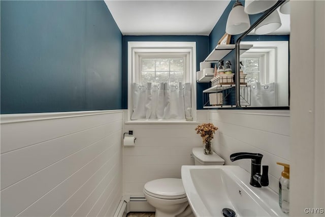 bathroom with a baseboard radiator, sink, and toilet