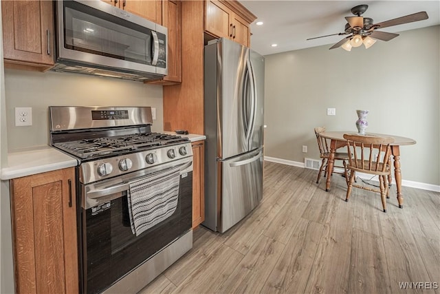 kitchen with ceiling fan, appliances with stainless steel finishes, and light hardwood / wood-style flooring