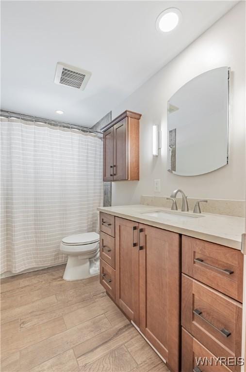 bathroom with vanity, hardwood / wood-style floors, curtained shower, and toilet